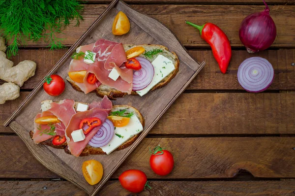 Ciabatta smörgås med salladsblad, jamon serrano och mozzarella. Ovanifrån. Selektivt fokus. Trä rustik bakgrund — Stockfoto