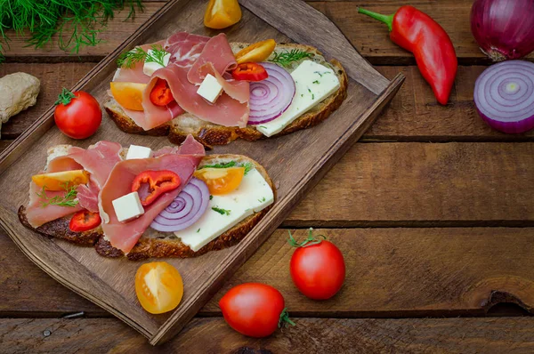 Sanduíche de Ciabatta com folhas de salada, jamon serrano e mussarela. Vista superior. Foco seletivo. Fundo rústico de madeira — Fotografia de Stock