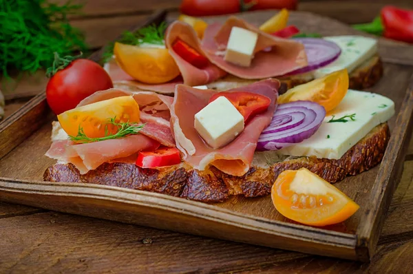 Ciabatta-Sandwich mit Salatblättern, Marmeladenserrano und Mozzarella. Ansicht von oben. Selektiver Fokus. Holz rustikalen Hintergrund — Stockfoto