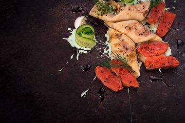 Krep somon ve siyah bir zemin üzerine sos ile. Yatay Üstten Görünüm