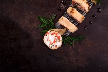 Somon, horseradish krem peynir ile ince krep rulo. Eski siyah arka plan. Üstten Görünüm. Seçici odak