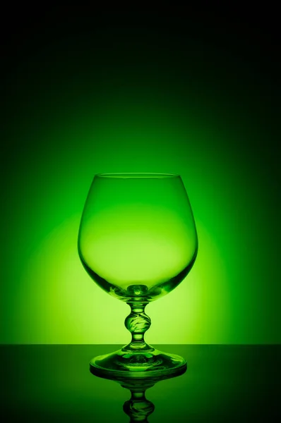 Wineglass σχετικά με ένα χρώμα φόντου με ένα μαύρο βινιέτα. Ένα ψηλό ποτήρι κρασιού με έναν λεπτό μίσχο — Φωτογραφία Αρχείου
