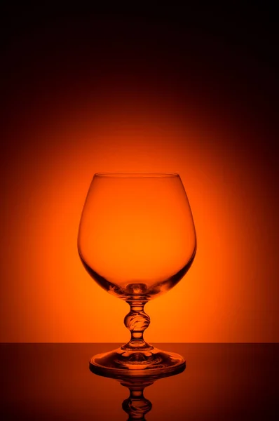 Wineglass on a color background with a black vignette. A tall Wineglass with a thin stalk — Stock Photo, Image