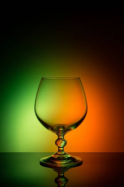 Wineglass on a color background with a black vignette. A tall Wineglass with a thin stalk — Stock Photo, Image