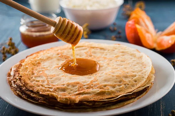 Fresh pancakes with honey, maple syrup, cottage cheese and tangerines. Wooden background. Top view — Stock Photo, Image