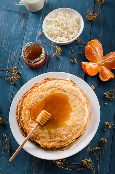 Frische Pfannkuchen mit Honig, Ahornsirup, Quark und Mandarinen. Holzuntergrund. Ansicht von oben — Stockfoto