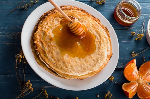 Fresh pancakes with honey, maple syrup, cottage cheese and tangerines. Wooden background. Top view — Stock Photo, Image