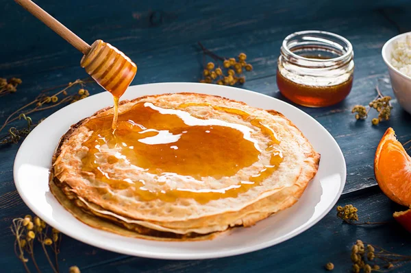 Fresh pancakes with honey, maple syrup, cottage cheese and tangerines. Wooden background. Top view — Stock Photo, Image