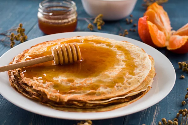 Fresh pancakes with honey, maple syrup, cottage cheese and tangerines. Wooden background. Top view — Stock Photo, Image