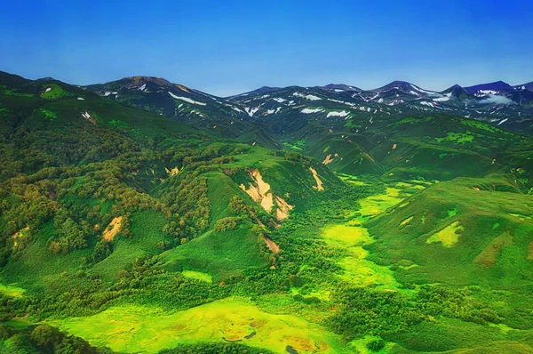 Kamcsatka. Vad természet. Zöld mezők és a vulkánok. Nézd a helikopter. — Stock Fotó