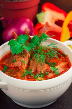 Pancar çorbası et ve beyaz tabakta Yeşiller ile. Geleneksel Ukraynalı Rus kırmızı çorba. Eski siyah rustik geçmiş. Üstten Görünüm