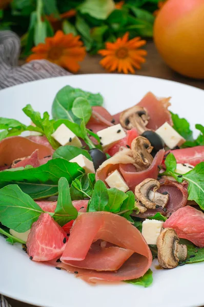 Salada com espinafre, queijo, presunto, toranja e molho balsâmico em um fundo rural de madeira. Vista superior. Close-up — Fotografia de Stock