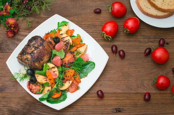 Rindersteak mit gegrilltem Gemüse, Spinat und Grapefruit mit Äpfeln. rustikalen hölzernen Hintergrund. Ansicht von oben — Stockfoto