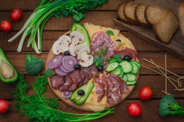 Jambon, salam, pastırma, domuz eti, peynir, mantar, salatalık, ekmek, avokado, soğan ve zeytin soğuk füme et. Ahşap rustik arka plan. Üstten Görünüm — Stok fotoğraf