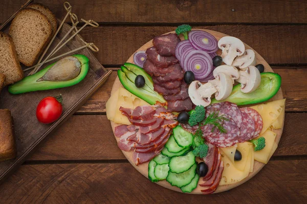Kallrökt kött med prosciutto, salami, bacon, Fläskkotletter, ost, svamp, gurka, bröd, avokado, lök och Oliver. Trä rustik bakgrund. Ovanifrån — Stockfoto