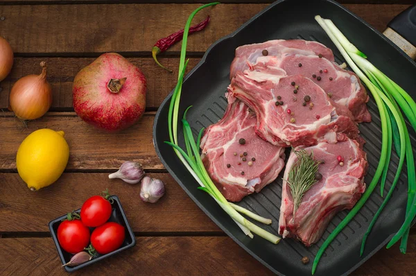 Ingredienti per la cottura costoletta roast beef bistecca su padella in ferro nero alla griglia. Sfondo rustico in legno. Vista dall'alto, composizione orizzontale — Foto Stock