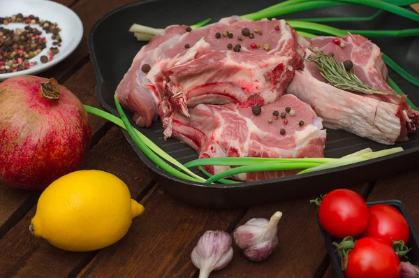 Ingredienti per la cottura costoletta roast beef bistecca su padella in ferro nero alla griglia. Sfondo rustico in legno. Vista dall'alto, composizione orizzontale — Foto Stock