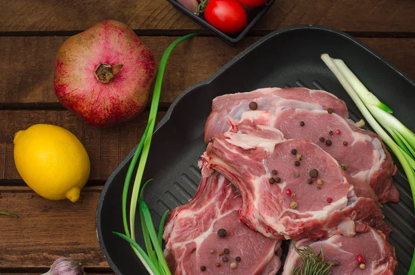 Ingredienti per la cottura costoletta roast beef bistecca su padella in ferro nero alla griglia. Sfondo rustico in legno. Vista dall'alto, composizione orizzontale — Foto Stock