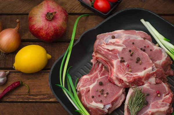 Ingredience pro vaření žebra eye pečené hovězí steak na černé železné grilovací pánev. Dřevěný rustikální pozadí. Pohled shora, horizontální kompozice — Stock fotografie