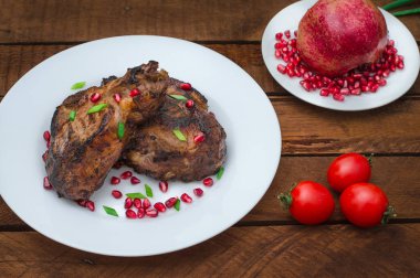 Narlı beyaz bir plaka üzerinde bir ızgarada pişmiş pirzola, biftek. Ahşap rustik arka plan. Üstten Görünüm