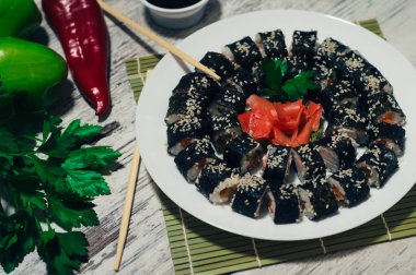 Suşi plaka üzerinde. Popüler sushi Japonya gıda. Ahşap rustik arka plan. Üstten Görünüm