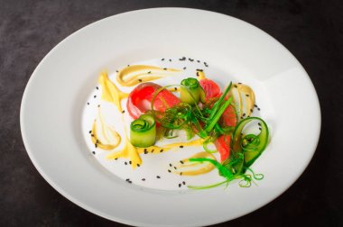 Somon, deniz yosunu ve salatalık ile çanağı. Eski siyah rustik geçmiş. Üstten Görünüm