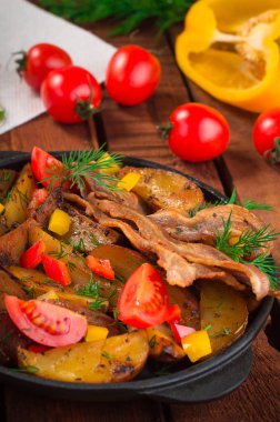 Pastırma ve tavada taze domates ile kızarmış patates. Ahşap rustik arka plan. Üstten Görünüm