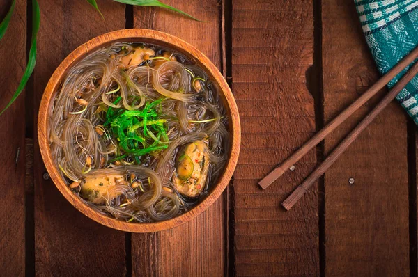 Cucina giapponese, zuppa di maiale chashu, erba cipollina, germogli, tagliatelle e alghe sul tavolo sotto la luce del sole. Sfondo rustico in legno. Vista dall'alto — Foto Stock