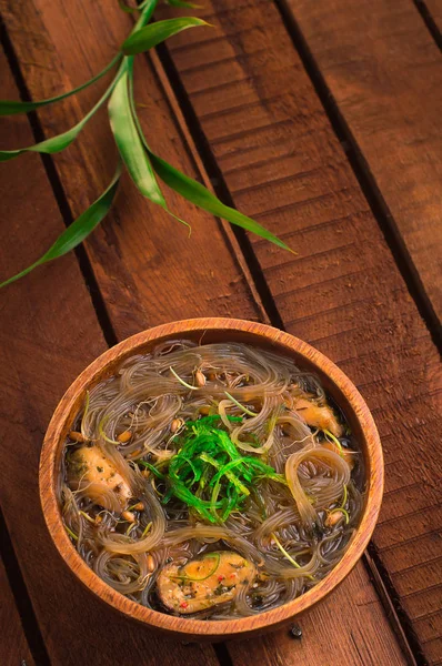 Cucina giapponese, zuppa di maiale chashu, erba cipollina, germogli, tagliatelle e alghe sul tavolo sotto la luce del sole. Sfondo rustico in legno. Vista dall'alto — Foto Stock