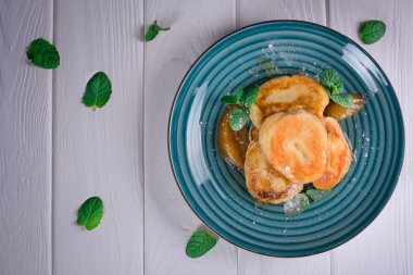 Karamelize armut ve çay limon ve nane ile krep. Seçici odak. Ahşap beyaz arka plan. Üstten Görünüm