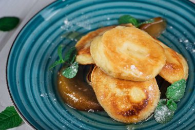 Karamelize armut ve çay limon ve nane ile krep. Seçici odak. Ahşap beyaz arka plan. Üstten Görünüm