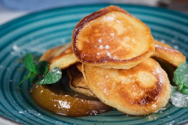 Karamelize armut ve çay limon ve nane ile krep. Seçici odak. Ahşap beyaz arka plan. Üstten Görünüm