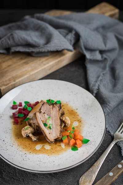 Revbensspjäll med rödbetor, morötter, stekt svamp och sås på en vit platta. Restaurang som serverar. Gammal svart rustik bakgrund. Ovanifrån — Stockfoto