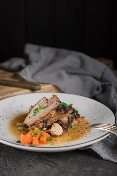 Revbensspjäll med rödbetor, morötter, stekt svamp och sås på en vit platta. Restaurang som serverar. Gammal svart rustik bakgrund. Ovanifrån — Stockfoto