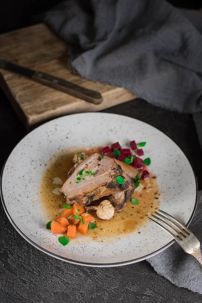 Revbensspjäll med rödbetor, morötter, stekt svamp och sås på en vit platta. Restaurang som serverar. Gammal svart rustik bakgrund. Ovanifrån — Stockfoto