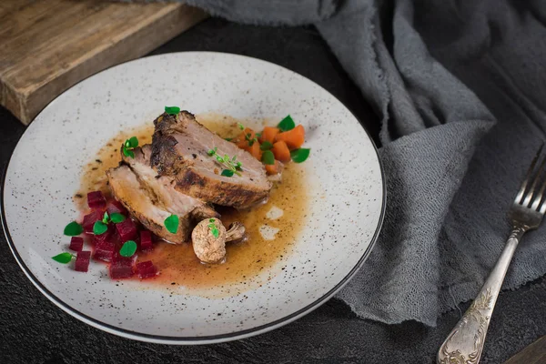 Revbensspjäll med rödbetor, morötter, stekt svamp och sås på en vit platta. Restaurang som serverar. Gammal svart rustik bakgrund. Ovanifrån — Stockfoto