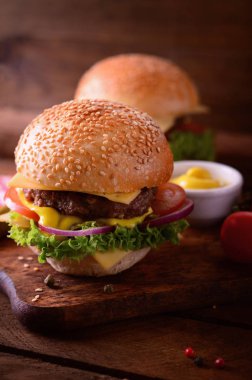 Fresh burger closeup. Wooden rustic background. Top view clipart