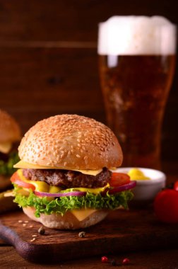 Taze hamburger closeup ve bira. Ahşap rustik arka plan. Üstten Görünüm