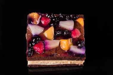 Jöle ve krema ile meyve pasta parçası. Siyah arka plan. Üstten Görünüm