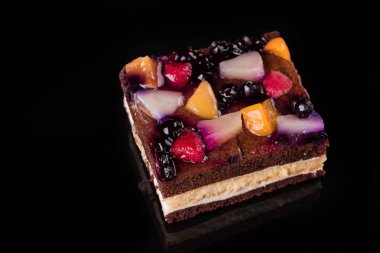 Jöle ve krema ile meyve pasta parçası. Siyah arka plan. Üstten Görünüm