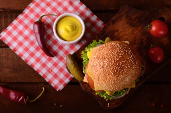 Closeup čerstvé burger. Dřevěný rustikální pozadí. Pohled shora — Stock fotografie