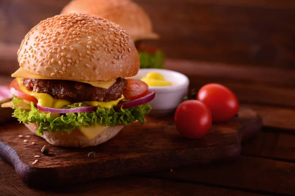 Closeup čerstvé burger. Dřevěný rustikální pozadí. Pohled shora — Stock fotografie