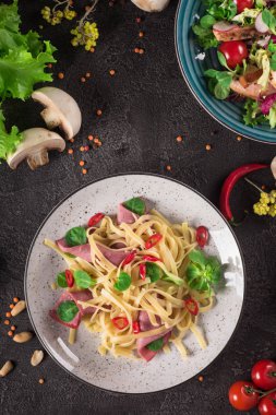 İtalyan spagetti. Ham Tagliatelle makarna. Seçici odak. Siyah arka plan. Üstten Görünüm