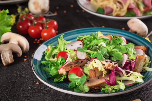 Zeleninový salát s grilovaným kuřecím masem-rajčata, ředkvičky a směs salátových listů. Kuřecí salát. Zdravé jídlo. Černé pozadí. Pohled shora — Stock fotografie