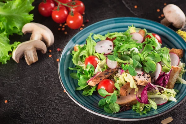 Izgara tavuk göğsü - domates, turp ve karışım marul yaprakları taze sebze salatası. Tavuk salatası. Sağlıklı gıda. Siyah arka plan. Üstten Görünüm — Stok fotoğraf