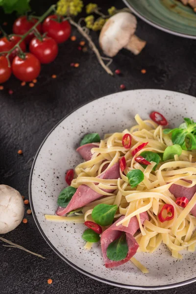 Espaguetis italianos. Pasta Tagliatelle con jamón. Enfoque selectivo. Fondo negro. Vista superior — Foto de Stock