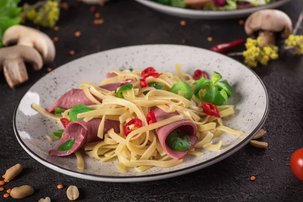 Olasz spagetti. Tagliatelle tészta-Ham. Szelektív összpontosít. Fekete háttér. Szemközti nézet — Stock Fotó