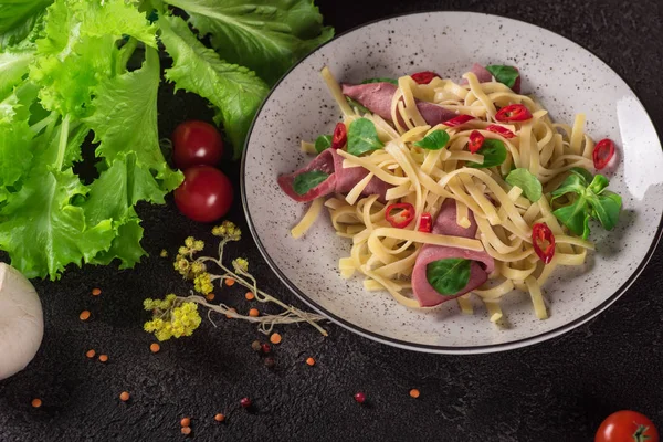 İtalyan spagetti. Ham Tagliatelle makarna. Seçici odak. Siyah arka plan. Üstten Görünüm — Stok fotoğraf