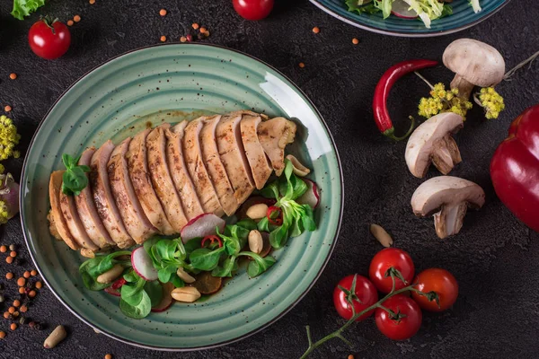 Kip biefstuk geroosterd en salade, culinaire fotografie. Zwarte achtergrond. Bovenaanzicht — Stockfoto