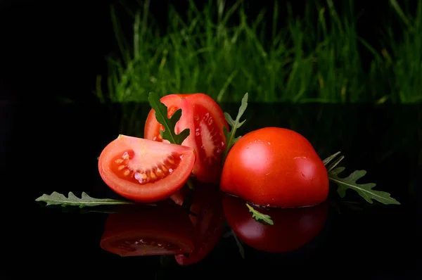 Pomodoro isolato su fondo nero e lucido con riflesso realistico e gocce d'acqua — Foto Stock